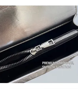 Close-up of metallic silver woven bag showing smooth zipper and black fabric lining