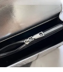 Close-up of metallic silver woven bag showing smooth zipper and black fabric lining