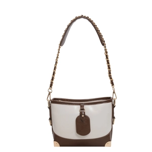 Contrast color bucket bag with metallic corners and chain strap in cream and brown
