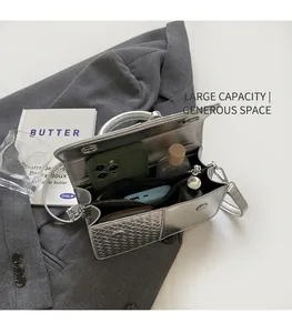 Interior view of silver metallic bag showing spacious compartments for phone and cosmetics