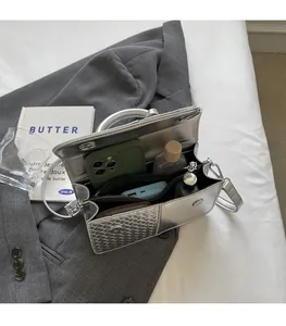 Interior view of silver metallic bag showing spacious compartments for phone and cosmetics