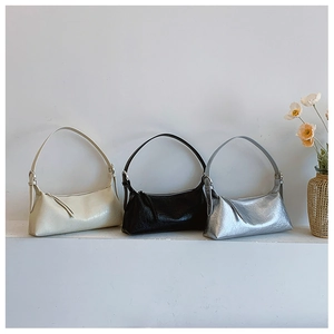 Detailed row of underarm bags in cream, black, and silver with wrinkled metallic texture