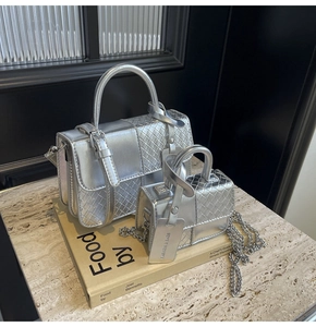 Silver woven texture handbag set with chain strap and fashion tag on a book