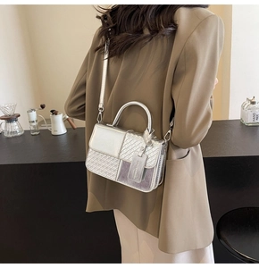 Silver woven texture shoulder bag shown on model with adjustable strap and chic tag