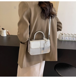 Detail view of silver woven textured handbag with metallic finish and top handle