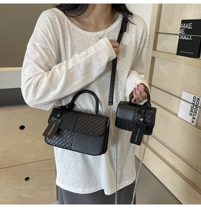 Detailed shot of black woven texture leather bag with mini chain pouch on a model