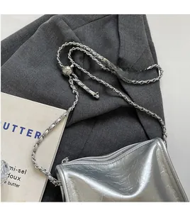 Détail du sac bandoulière argenté métallisé avec texture froissée et chaîne ajustable