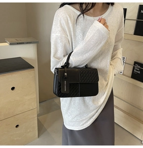 Close-up of black woven texture and smooth leather finish on a stylish handbag