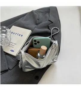 Détail intérieur du sac à bandoulière argenté révélant un grand espace de rangement