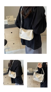 Détail du sac à bandoulière en cuir PU blanc avec chaîne argentée et breloque boule