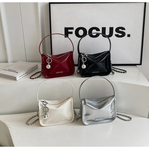 Détail montrant divers sacs à bandoulière tendance avec chaînes et pendentifs métalliques