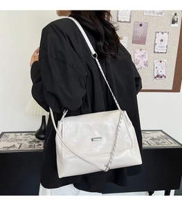 Cream quilted chain crossbody bag with diamond stitching shown on a person for scale