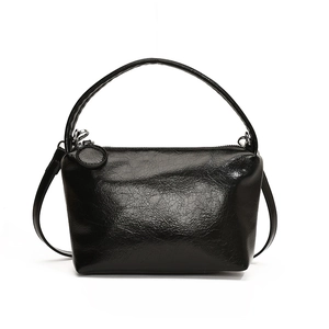 Minimalist black glossy leather handbag with shoulder strap and pleated texture detail
