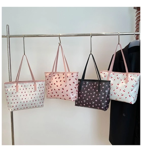 Détail de quatre sacs fourre-tout imprimés avec motifs de fraises, cerises et nœuds