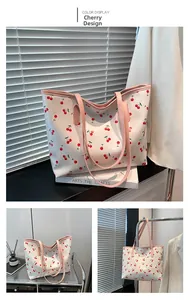 Détail du sac cabas blanc avec imprimé cerises et anses roses en décor esthétique