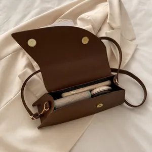 Borsa a tracolla marrone che mostra lo spazio interno per cellulare e trucchi