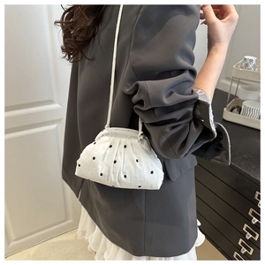 Gros plan détaillé du sac nuage plissé blanc avec motif floral noir et fine bandoulière