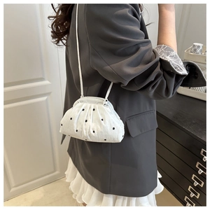 Détail du sac bandoulière plissé blanc avec broderie florale noire et fine lanière