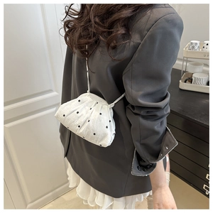 Détail d'un sac bandoulière blanc à fleurs avec design plissé et fine sangle d'épaule