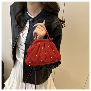 Gros plan du sac nuage rouge à volants avec broderie florale blanche et fine poignée