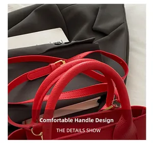 Detail view of red lychee grain leather handbag with comfortable handle and gold hardware