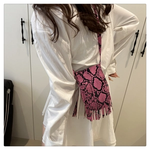 Detail of pink snakeskin pattern crossbody bag featuring long stylish fringes