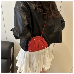 Gros plan sur un sac bandoulière rouge à fleurs avec volants et motif de petites fleurs