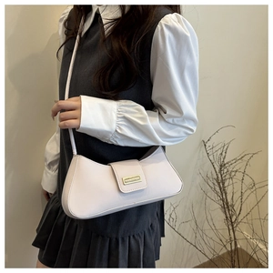 Close-up of cream faux leather half-moon baguette bag with metal clasp and thin strap