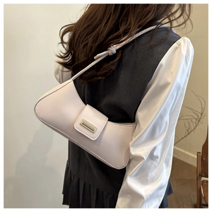 Detail of minimalist leather shoulder bag with sleek gold buckle and slim strap