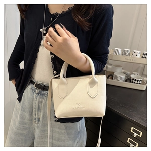 Nahaufnahme der weißen Mini-Handtasche aus Leder mit Litschi-Muster und Schultergurt