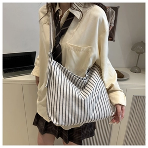 Close-up of a black and white striped canvas tote bag in a casual preppy school style