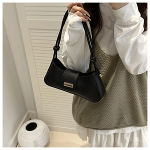 Black leather baguette bag with metal clasp and knotted handle shown on model