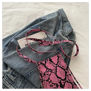 Detail of pink python print crossbody bag with long tassels and adjustable strap