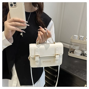 White faux leather crossbody bag styled with a shoulder strap for a chic outfit look