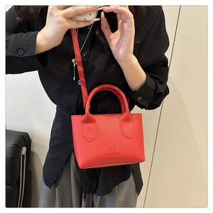 Detailansicht rote Lederhandtasche mit DX-Logo und verstellbarem Schultergurt aus Leder