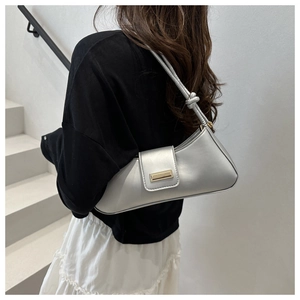 Detail of silver metallic baguette bag with gold buckle and knotted shoulder strap