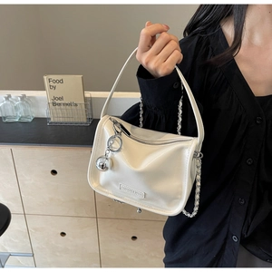 Sac à bandoulière en cuir verni blanc avec chaîne métallique et pendentif boule miroir