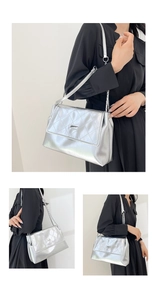 Detail of silver quilted chain bag with metallic finish and adjustable shoulder strap