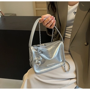 Détails du sac bandoulière argenté métallisé avec charme boule miroir et bandoulière chaîne