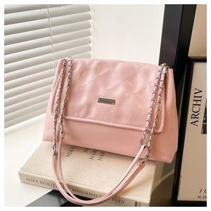Detail of pink quilted PU leather bag with silver metal bar and chain shoulder strap