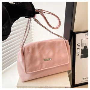 Close-up of pink quilted faux leather shoulder bag with silver metal buckle and chain strap