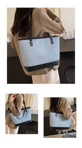Detail showing the large light blue denim tote bag with black leather straps and trim
