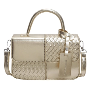 Golden metallic woven crossbody bag with top handle and fashion hanging tag on white background