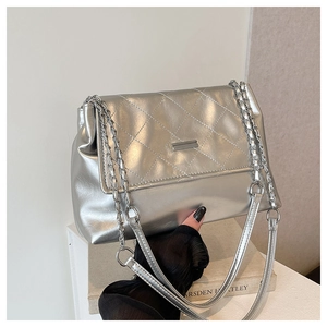 Detail of silver quilted chain bag with metallic finish and rectangular metal buckle