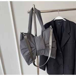 Detail of grey nylon bow bag with adjustable shoulder strap and wide top handle