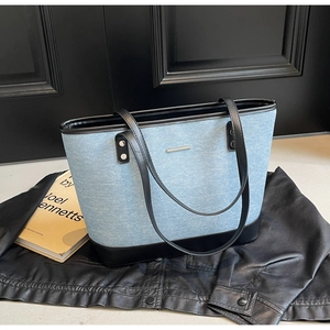 Large capacity denim tote bag featuring black leather trim and silver metal hardware detail