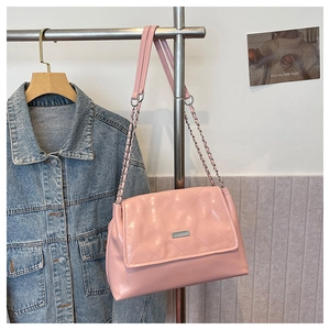 Detail of pink quilted shoulder bag with metal chain strap and glossy finish