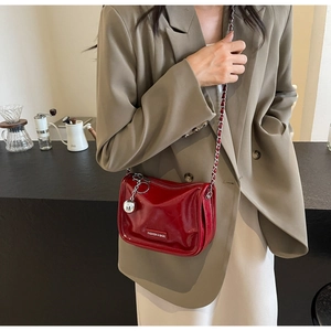 Sac à bandoulière en cuir verni rouge brillant avec chaîne argentée et pendentif sphère
