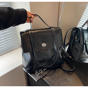 Détail du sac cabas en cuir froissé noir avec fermoir rotatif argenté et bandoulière