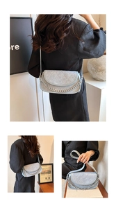 Detail of light blue quilted crossbody bag with stylish silver chain and denim texture